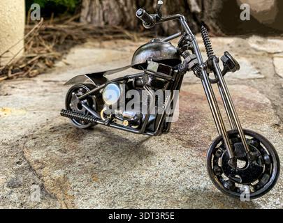 Modello di moto in miniatura in stile vintage esposto all'aperto su superfici in pietra. Foto Stock
