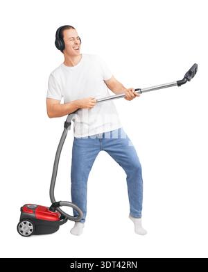 Giovane con le cuffie che suona l'aspirapolvere come una chitarra. Ragazzo felice che si diverte mentre pulisce casa isolata su sfondo bianco. Alta qualità fot Foto Stock