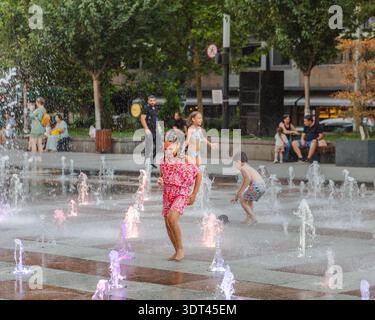 Yerevan, Armenia - 26 agosto 2025: Vista dei bambini che giocheranno con gioia nelle vivaci fontane illuminate, le loro risate risuonano tra le W della città Foto Stock