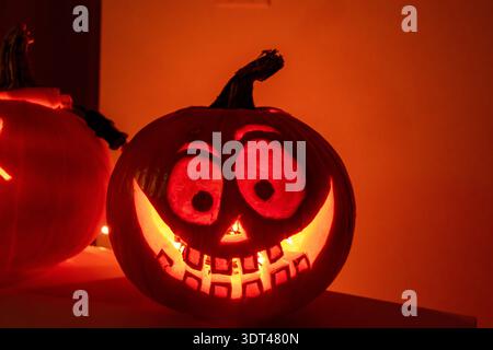 Primo piano di una zucca di Halloween scolpita e vellutata di colore rosso nell'oscurità di Vancouver, Canada Foto Stock