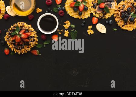 Collage di cialde con frutta e sciroppo su superficie scura al mattino Foto Stock