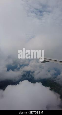Ali di aeroplano che si innalzano sopra soffici nuvole bianche Foto Stock