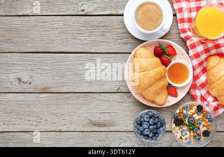 Colazione di mattina con caffè, pasticcini e frutta su tavolo di legno Foto Stock