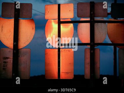 Il retro dei cartelli autostradali dell'interstate si illumina di luce sul cielo crepuscolo Foto Stock