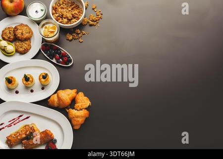 Colazione con vari cibi collocati su una superficie scura Foto Stock