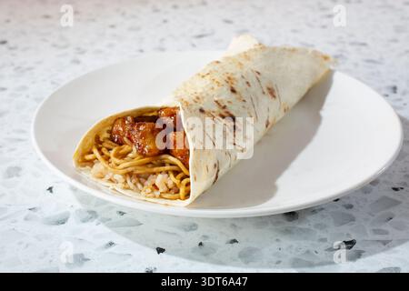 Una vista di un burrito di pollo all'arancia, su un piatto. Foto Stock