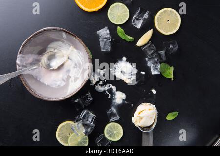 Avanzi di dessert dolce con fette di agrumi e ghiaccio sul tavolo Foto Stock