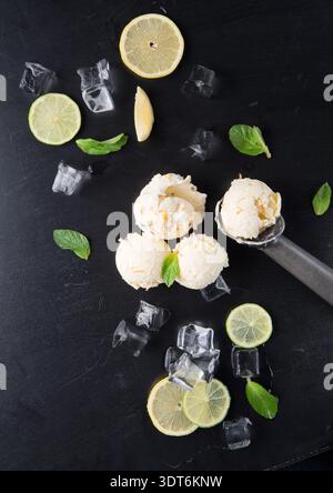 Gelato con limone, menta e ghiaccio su superficie nera durante il pomeriggio estivo Foto Stock