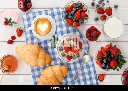 Colazione a buffet con frutta fresca, croissant e caffè su una tovaglia a scacchi al mattino Foto Stock