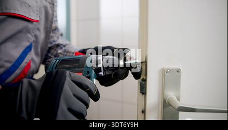 L'esperto fabbro ha provveduto alla sostituzione Di Una serratura danneggiata. Foto Stock