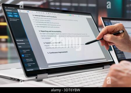 Uomo che rivede il documento sulla privacy del paziente su un laptop nello studio legale sanitario. Foto Stock