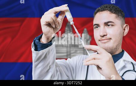 Medico che tiene la siringa sullo sfondo della bandiera cambogiana. Siringa di tenuta professionale medica con bandiera cambogiana sullo sfondo Foto Stock