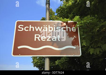 Cartello stradale marrone con testo davanti agli alberi e al cielo blu, Pleinfeld, Baviera, Germania Foto Stock