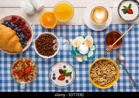 Colazione a buffet su una tovaglia a scacchi con vari cibi e bevande Foto Stock
