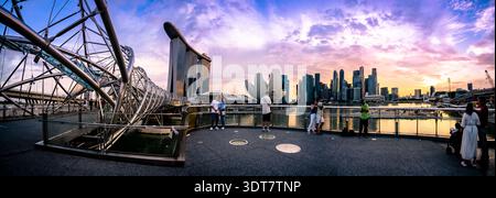 Vista panoramica dell'area di Marina Bay a Singapore, con l'Helix Bridge in primo piano e l'hotel Marina Bay Sands sullo sfondo. Foto Stock