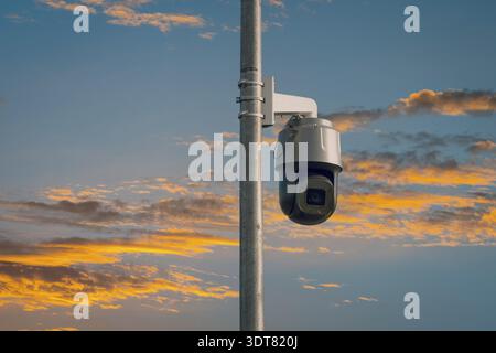 Telecamera CCTV di sicurezza su un palo con cielo al tramonto. Il concetto di sorveglianza serale Foto Stock