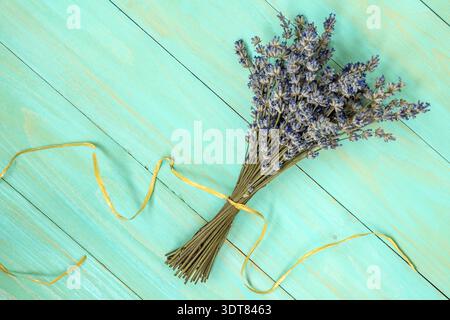 Mazzetto di estratto secco di fiori di lavanda in blu sullo sfondo di legno Foto Stock