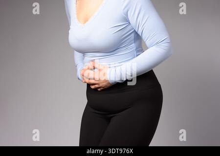 Immagine di una giovane donna con mestruazioni mal di stomaco dolore problemi di stringere lo stomaco. Malattia addominale del ventre nella persona femminile. Foto Stock