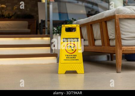 Segnale di pericolo di inciampo giallo vicino alla scala concetto di prevenzione della sicurezza interna. Foto Stock