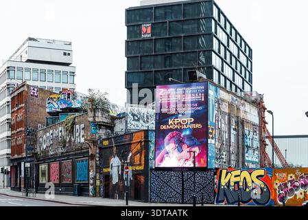 Graffiti Street art sulla Great Eastern Street, Shoreditch, inclusi due vecchi treni sotterranei sopra la strada. Adoriamo e resistiamo a vicenda Foto Stock
