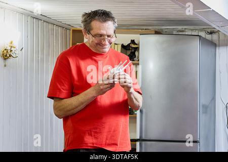 Allegro uomo maturo tiene in mano il ripetitore di segnale wifi. Foto Stock