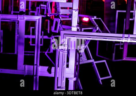un'installazione artistica astratta con numerosi telai rettangolari di varie dimensioni, impilati e sovrapposti. I telai sono illuminati dalla luce al neon Foto Stock