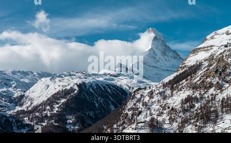 Cervino sopra le creste di neve vicino a Zermatt sotto il cielo limpido di mezzogiorno Foto Stock