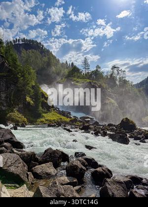 Potente cascata che crea nebbia nel paesaggio norvegese Foto Stock