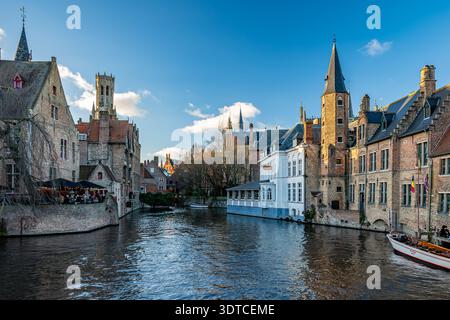 Bruges, Belgio - 14 febbraio 2026: Vista panoramica del canale Rozenhoedkaai con storiche case in mattoni e torri medievali nella città vecchia di Bruges. Foto Stock