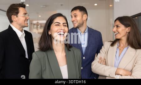 Colleghi che ridono, scambiano battute, rappresentano cameratismo, relazioni di lavoro positive Foto Stock