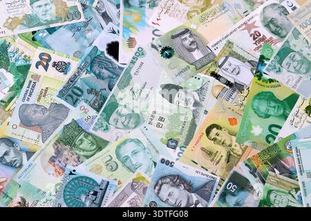 Varie valute banconote banconote di colore verde. Molte banconote in contanti da diversi paesi in grande pila da vicino. Economia mondiale e concetto di cambio valuta Foto Stock
