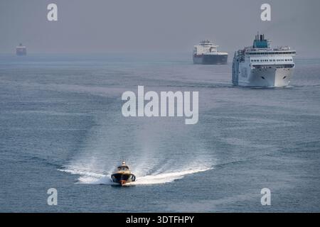 Pilota di porto che naviga di fronte alle navi che accedono al porto di Barcellona, Catalogna, Spagna Foto Stock
