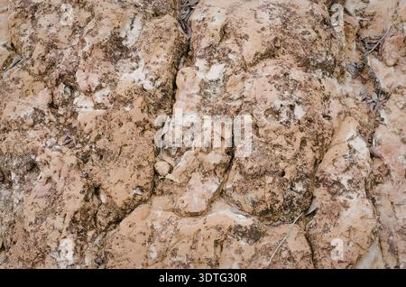 L'immagine mostra una vista ravvicinata di una superficie di terra incrinata con un colore prevalentemente marrone e fessure e fessure visibili. Foto Stock