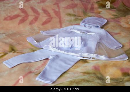 sdraiato sul letto un vestito bianco Foto Stock