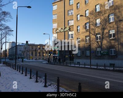 La gente cammina sulla strada vicino all'edificio con un cartello con il negozio in inverno Foto Stock