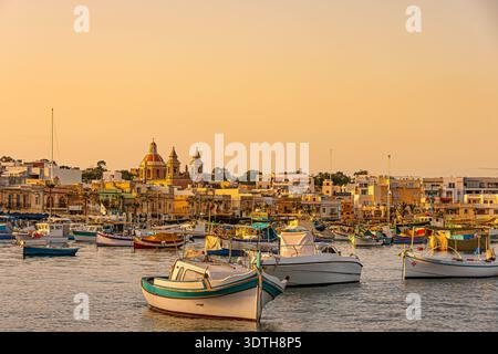 Barche ormeggiate di fronte al porto di Marsaxlokk, Malta. Foto Stock