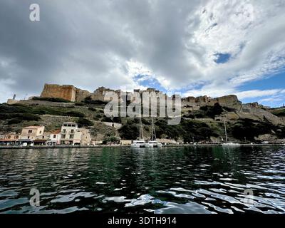 Porto e centro città di Bonifacio sulla punta meridionale della costa mediterranea corsa, fotografata dall'acqua in estate. Foto Stock