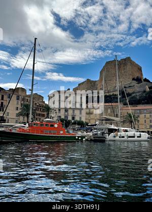 Porto e centro città di Bonifacio sulla punta meridionale della costa mediterranea corsa, fotografata dall'acqua in estate. Foto Stock