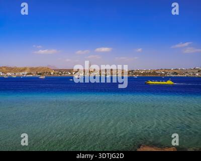 Panorama della baia di Sharm El-Maya con una barca turistica gialla nelle acque turchesi e azzurre del Mar Rosso a Sharm El Sheikh (Egitto). Paesaggio tropicale Foto Stock