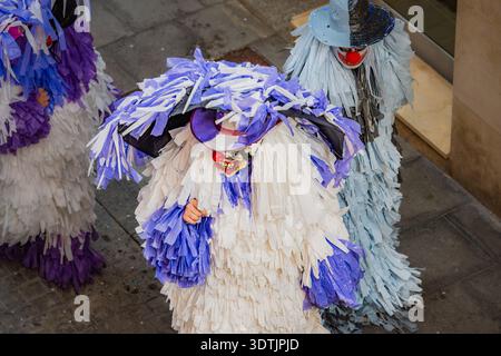 Persone vestite con costumi e maschere di carta colorati durante una tradizionale parata di carnevale, l'Ametlla, Spagna Foto Stock