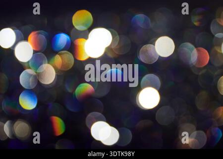 Un'immagine di sfondo astratta composta da numerose sorgenti luminose sfocate, che creano un effetto bokeh. Le luci variano per dimensioni e colore, incluso wh Foto Stock