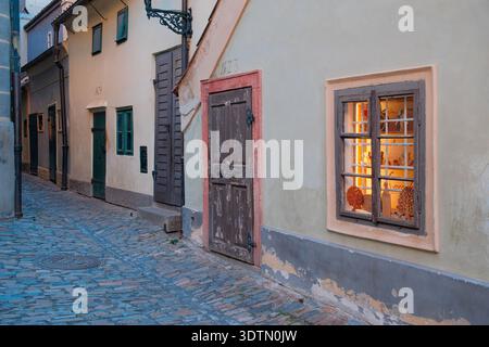 Praga, Repubblica Ceca - 12 agosto 2024: Piccole case storiche lungo il viale d'oro all'interno del castello di Praga. Lo stretto vicolo acciottolato è caratterizzato da pastel-co Foto Stock