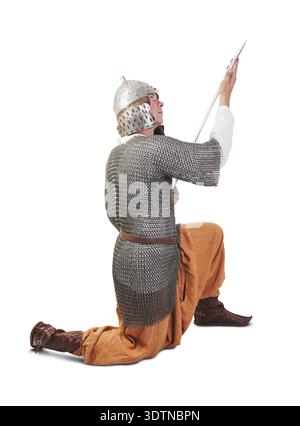 Guerriero medievale che indossa un'antica armatura con la spada Foto Stock