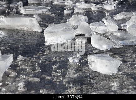 Blocchi di ghiaccio sulla superficie dell'acqua ghiacciata del lago durante l'inverno gelido Foto Stock