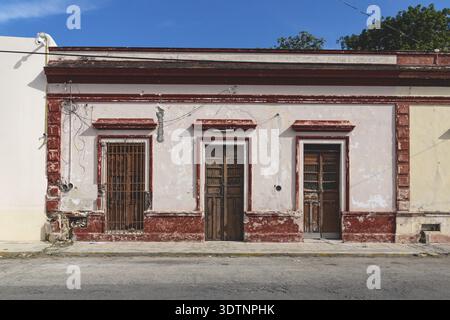 Facciata di tipico edificio coloniale abbandonato messicano con porte in legno a Merida, Yucatan, Messico Foto Stock