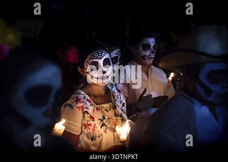 Merida, Cementerio generale, Messico - 31 Ottobre 2018: Donna con il cranio e la ragnatela di make-up e condire con la tradizionale messicano fiori circondata da Foto Stock