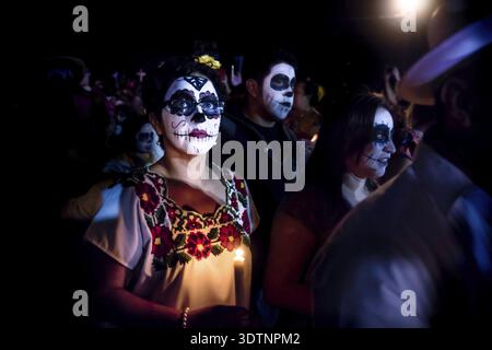 Merida, Cementerio generale, Messico - 31 Ottobre 2018: Donna con il cranio e la ragnatela di make-up e bicchieri e condire con la tradizionale messicano fiori su Foto Stock