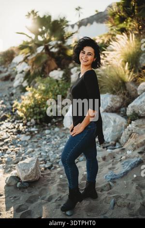 Ritratto di una bella donna ispanica latina che posa rocce all'aperto Foto Stock