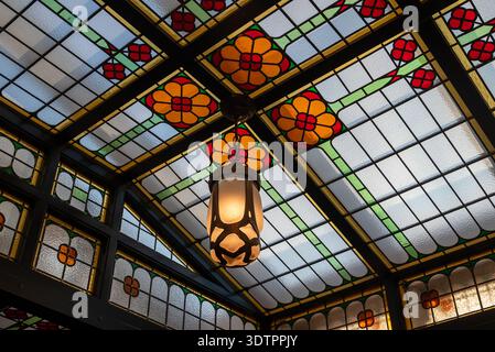 Le vetrate storiche incontrano l'arte moderna al Moco Museum di Amsterdam. Architettura decorata di Villa Alsberg del 1904 con eleganti dettagli e lampade sul soffitto. Foto Stock
