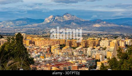 Alicante, Spagna - 20 gennaio 2026: Paesaggio urbano panoramico di Alicante con i quartieri urbani centrali e settentrionali e la catena montuosa della Serra de Mariola Foto Stock